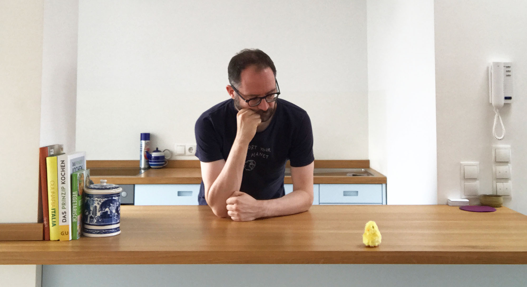 Martin having a heart-to-heart with a small yellow chick in the kitchen